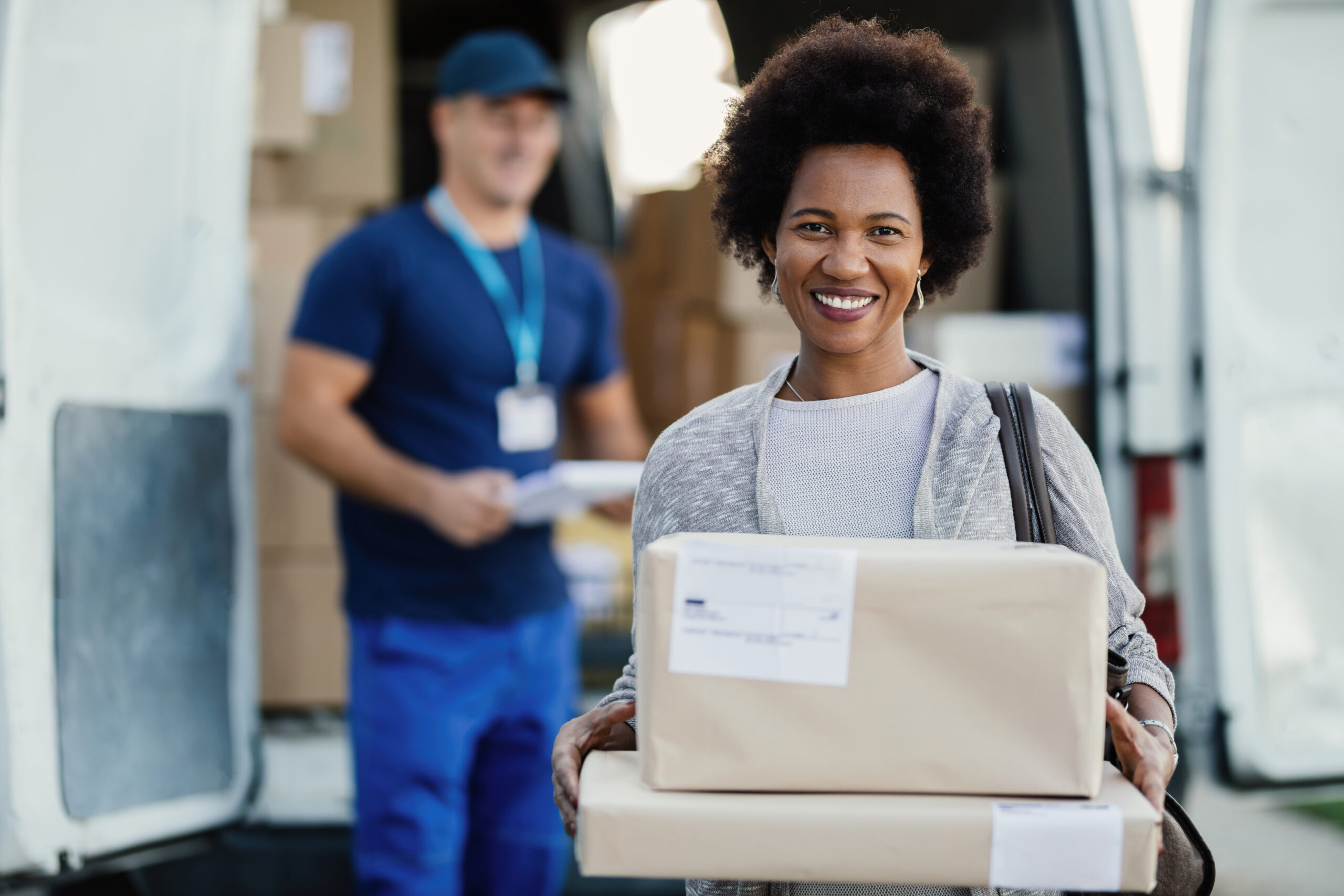 Portrait of satisfied African American woman holding her delivered packages.