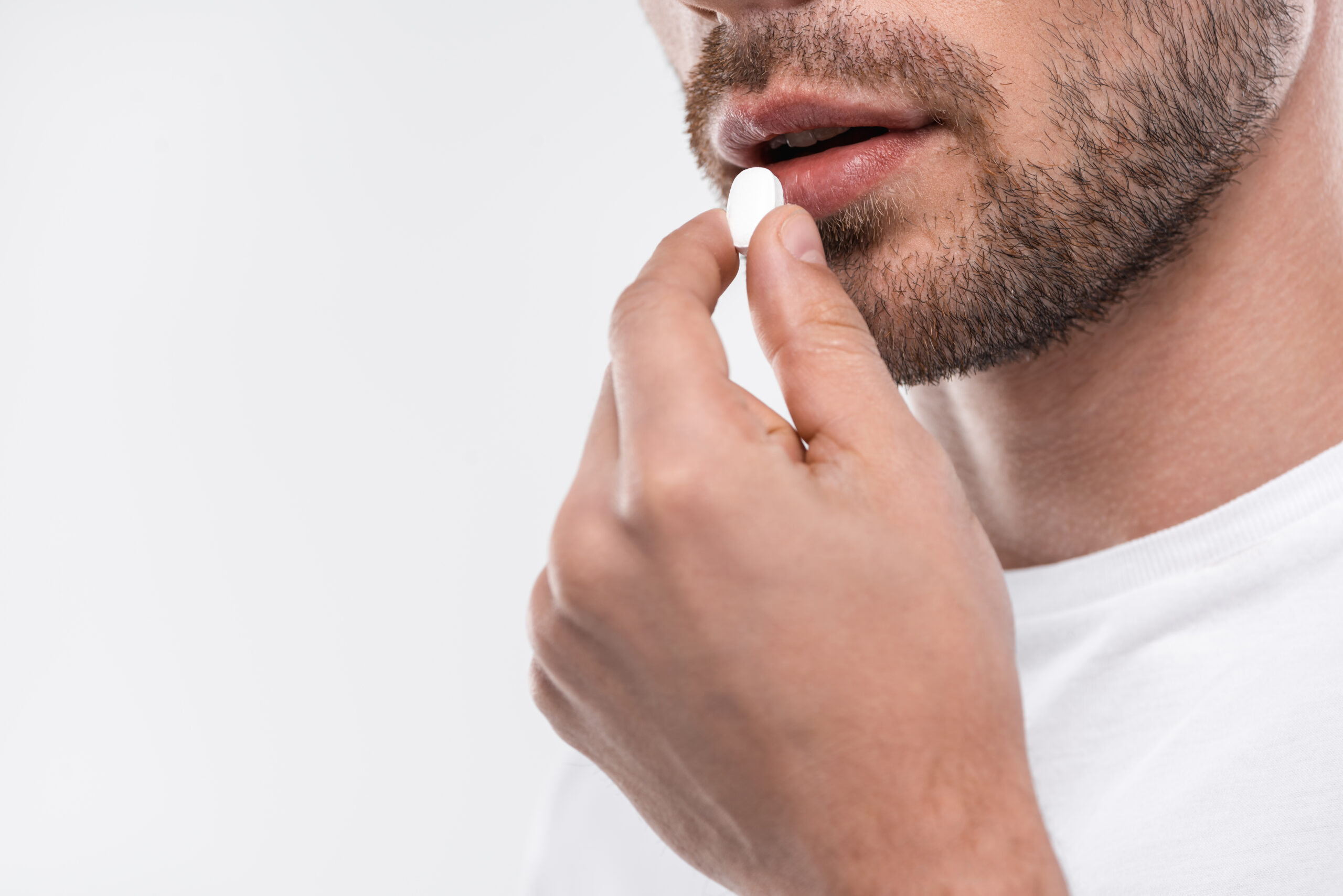 cropped view of man having pill, isolated on white